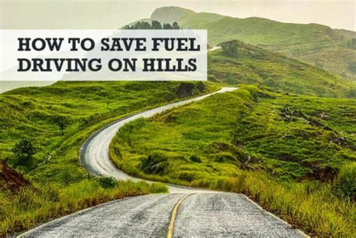 How can you save fuel while driving up hills?