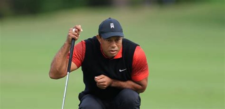 How does Tiger Woods hold his clubs?